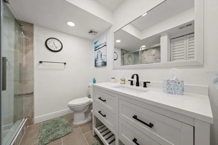 Guest bathroom featuring a custom-built shower and a beautiful vanity.