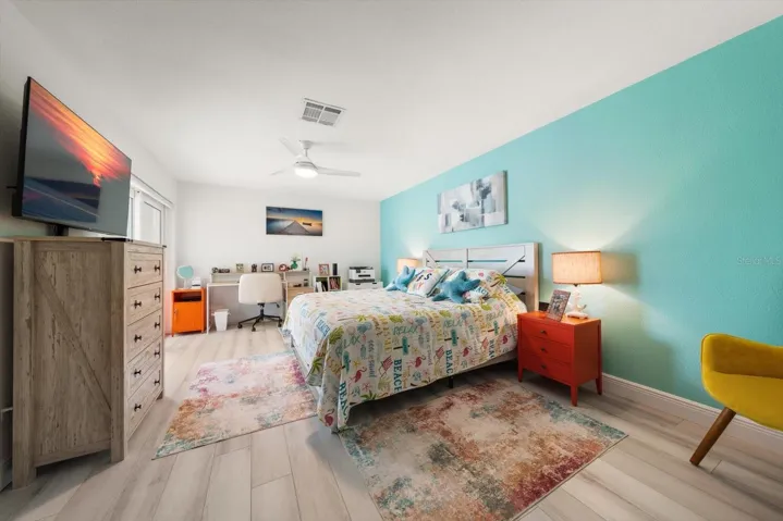 Guest room featuring vibrant, brilliant colors and a spacious layout that comfortably accommodates a small office desk.