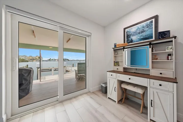 Makeup vanity area featuring stunning waterfront views—watch the dolphins while you get ready. Enjoy seamless access to the patio through the newly installed hurricane-rated sliding glass doors.