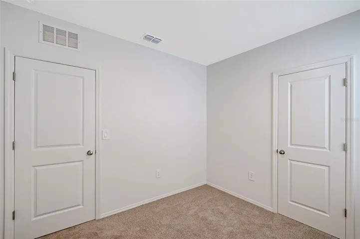 Comfortable guest bedroom with natural light and generous closet space.