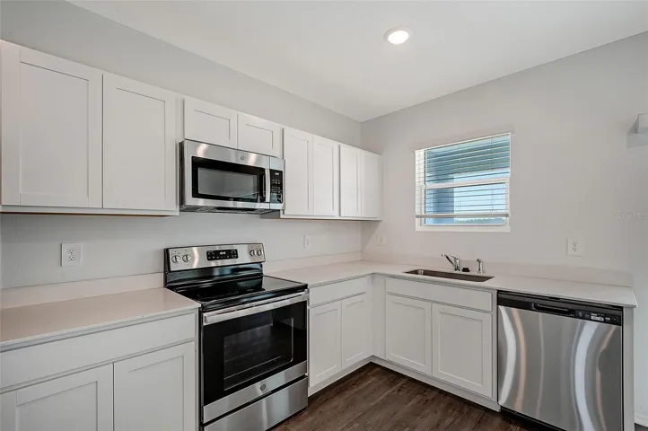 Well-appointed kitchen showcasing stainless steel appliances, ample cabinetry, generous counter space, and a functional layout.