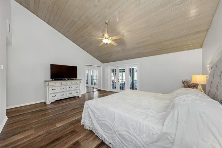 Primary bedroom with high wood ceiling and French doors