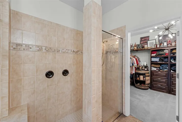 Walk-in shower with neutral tile and spacious design.