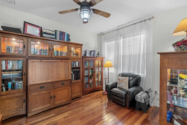 Private front office with wood flooring and ceiling fan.