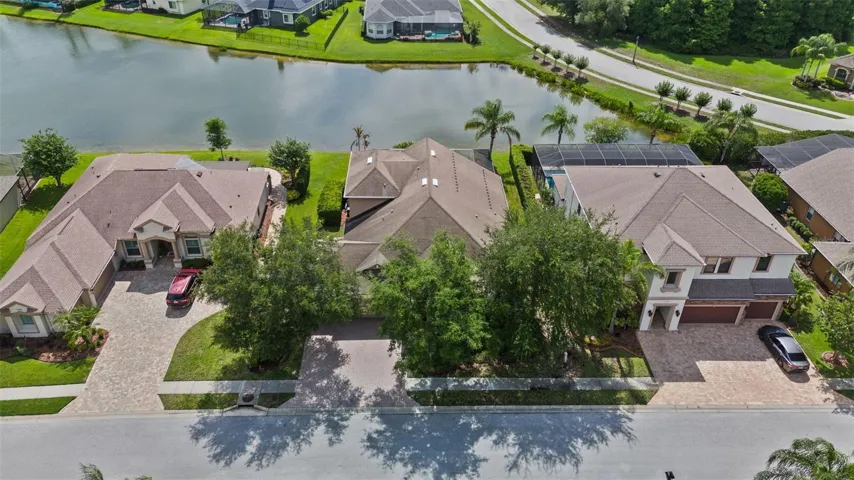 Aerial view of the home, driveway, and pond-front homesite.