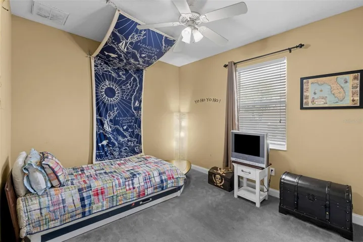 Secondary bedroom with vaulted ceiling and ceiling fan.