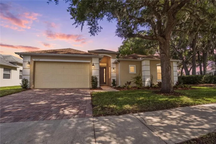 Front Exterior with covered front porch, pavered driveway, coach lighting and newly landscaped bed.