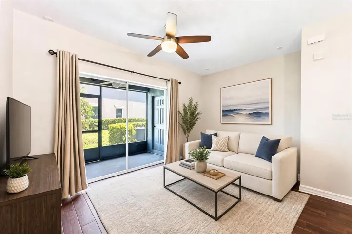 Living area has sliding glass door access to the screened lanai. Virtually Staged.