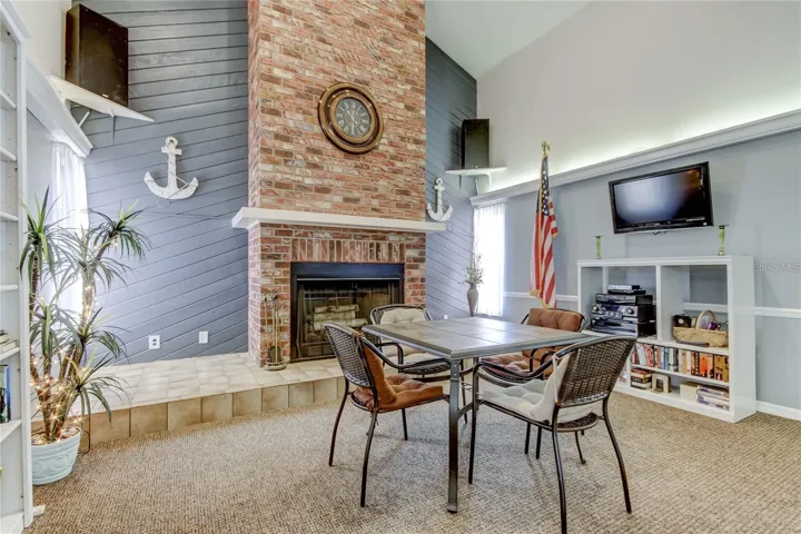 The clubhouse interior is warm and welcoming, featuring a cozy fireplace and a television for relaxation.