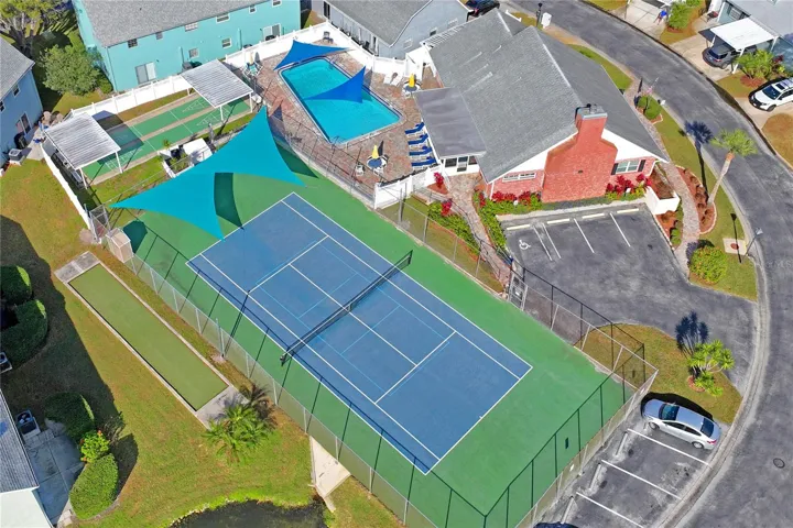 Aerial view of the amenities at The Wilds includes tennis courts, a heated pool, shuffleboard, and bocce.