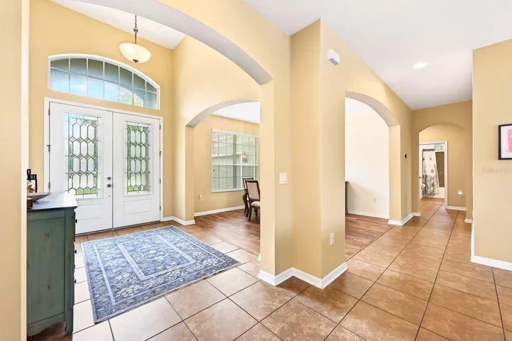 Inside, a grand foyer welcomes you into a home filled with GRACEFUL ARCHITECTURAL DETAILS, soaring 9-foot ceilings, and beautiful ceramic tile flooring throughout the main living areas.