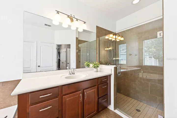A SPACIOUS PRIMARY EN SUITE BATH boasts split vanities, a garden tub, step-in shower, and private water closet.