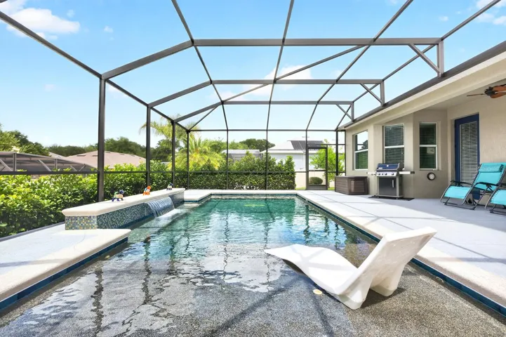 Added in 2023, the spectacular screened pool features a WATERFALL FEATURE, sun shelf, electric heater, and in-floor cleaning system, creating a luxurious setting for relaxation and entertaining year-round.