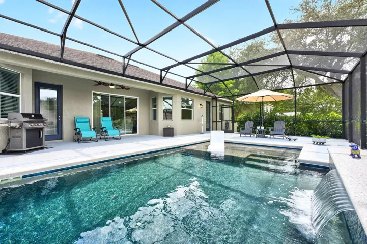 Added in 2023, the spectacular screened pool features a WATERFALL FEATURE, sun shelf, electric heater, and in-floor cleaning system, creating a luxurious setting for relaxation and entertaining year-round.