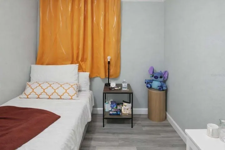 Spacious bedroom with warm natural light and room for a full furniture setup.