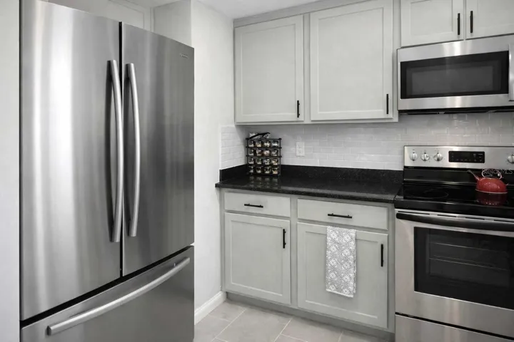 Modern kitchen featuring stainless steel appliances, sleek cabinetry, and updated tilework.