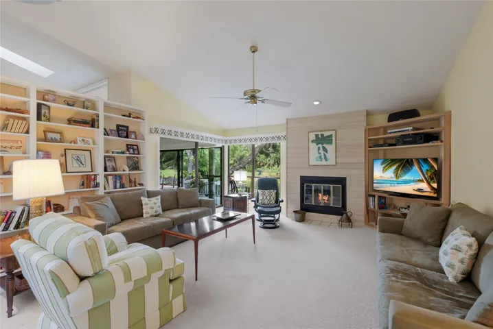 Living room with new carpet , custom shelving, and wood burning fireplace.