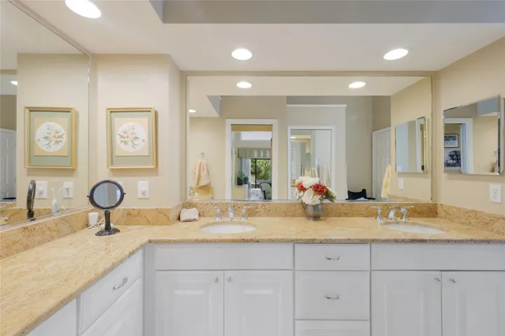 Primary bathroom with update cabinets and stone countertops.