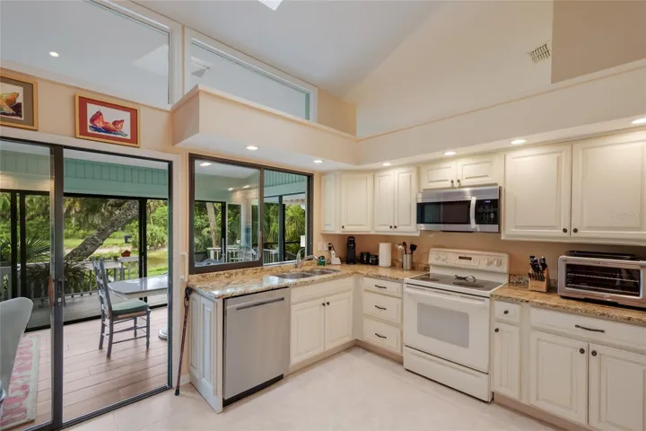 Kitchen with pond views, updated cabinets, and stone countertops.