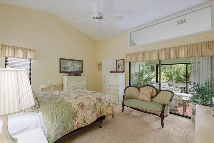 Primary bedroom with vaulted ceilings, walk-in closest, and views of the pond.