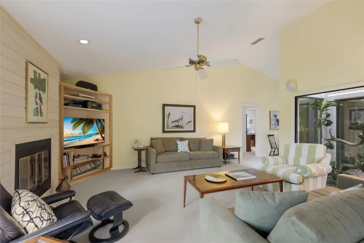 Living room with vaulted ceilings and views of the pond and atrium.