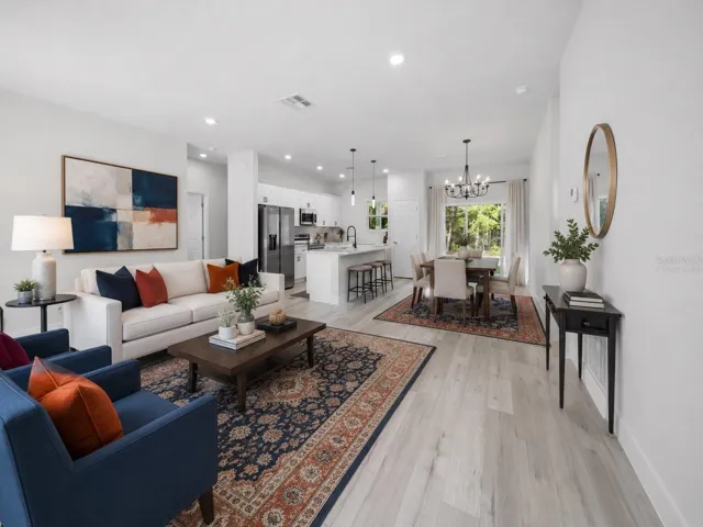 Open-concept living and dining area with abundant natural light - virtually staged