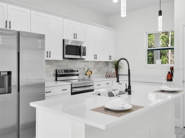 Gourmet kitchen with quartz countertops, stainless steel appliances, and oversized island