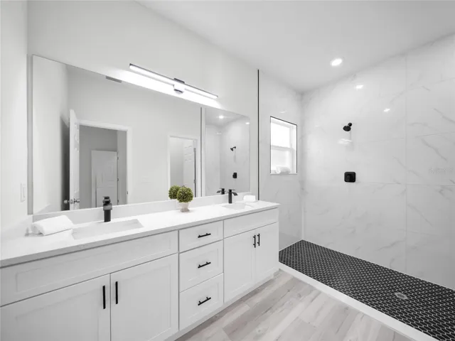 Spacious primary bathroom featuring dual vanities and oversized walk-in shower