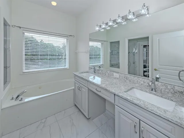 The primary bath has been upgraded with new flooring, quartz countertops, solid wood cabinetry and features dual sinks, garden tub, and glass shower, with private water closet