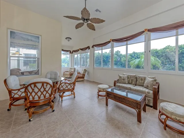 This very bright Florida room includes beautiful tropical views and private access to the rear yard