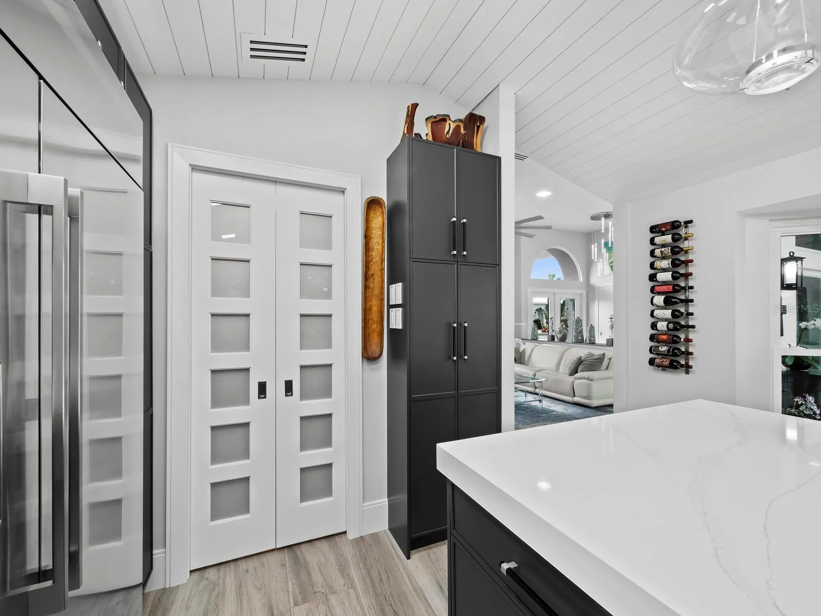 pocket doors to laundry, coffee bar with sink and floor to ceiling cabinets