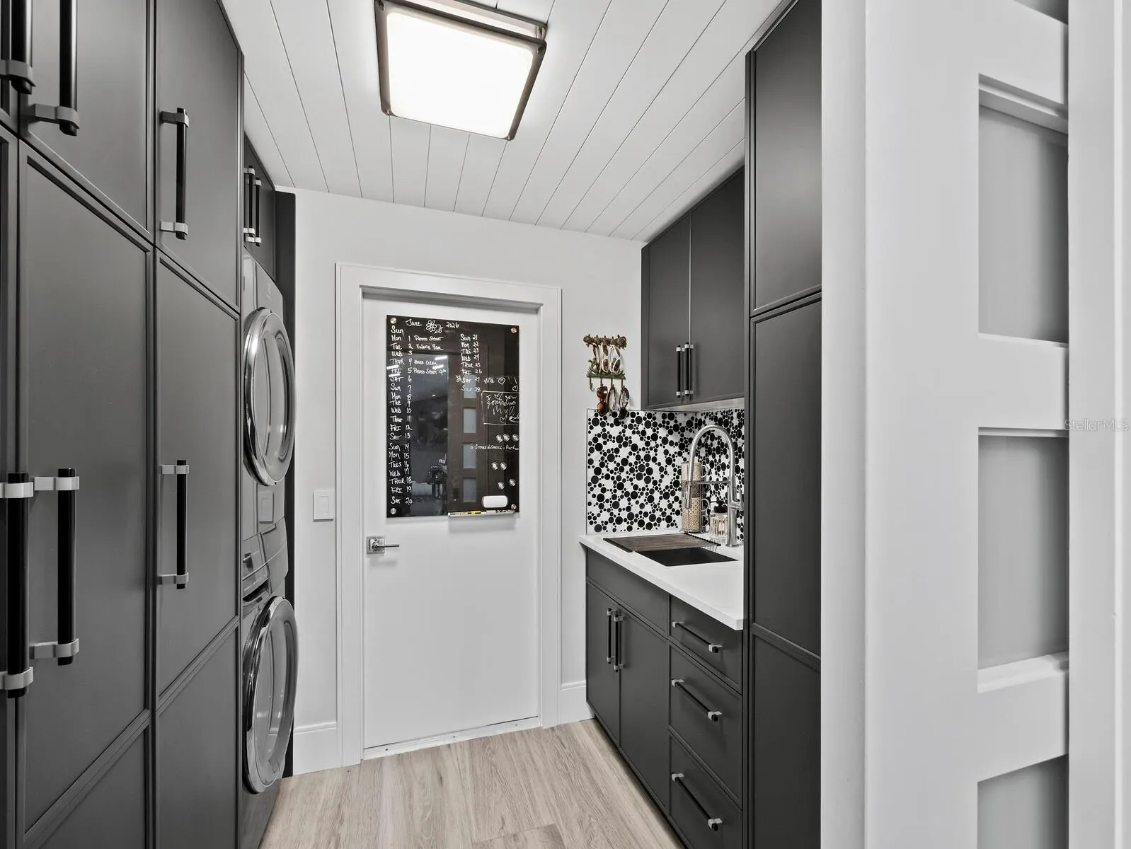laundry, coffee bar with sink and floor to ceiling cabinets