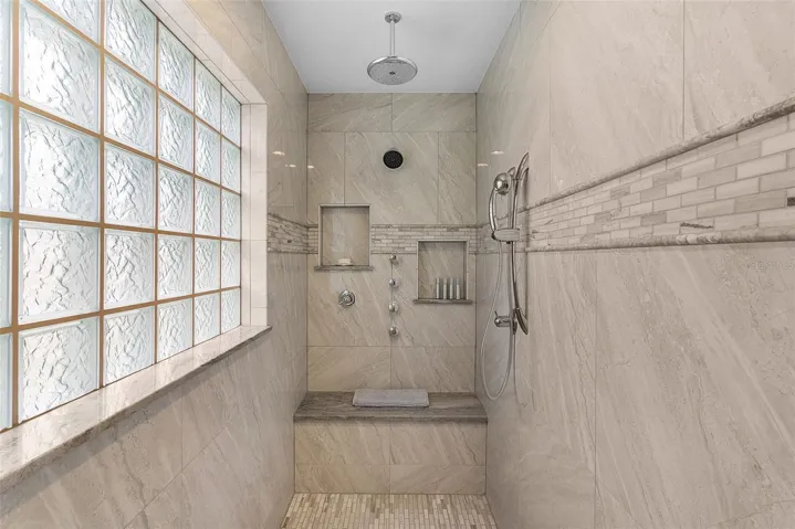 Another stunning tiled Roman shower with multiple shower heads!