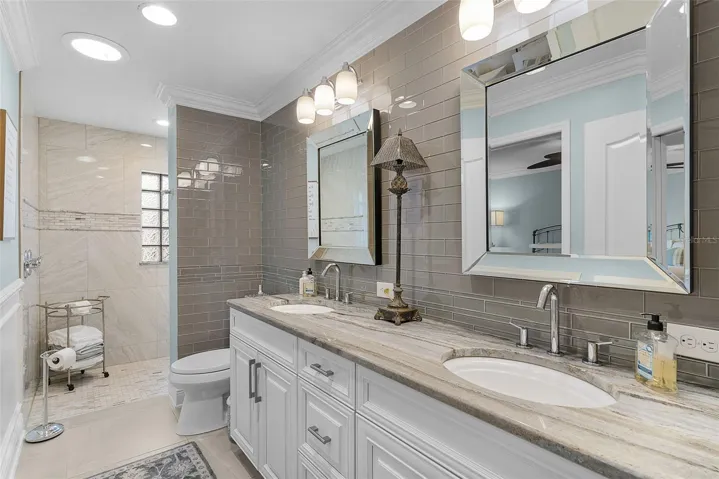 The guest bath has granite countertops and beautiful framed mirrors