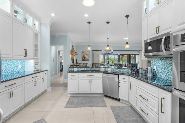 Kitchen with 3 pendant lights & cabinets up to the ceiling