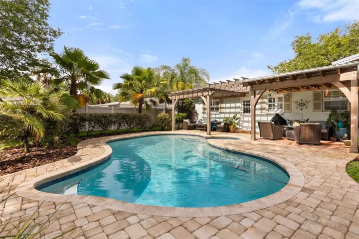 pool area with covered lanai and custom pergola.