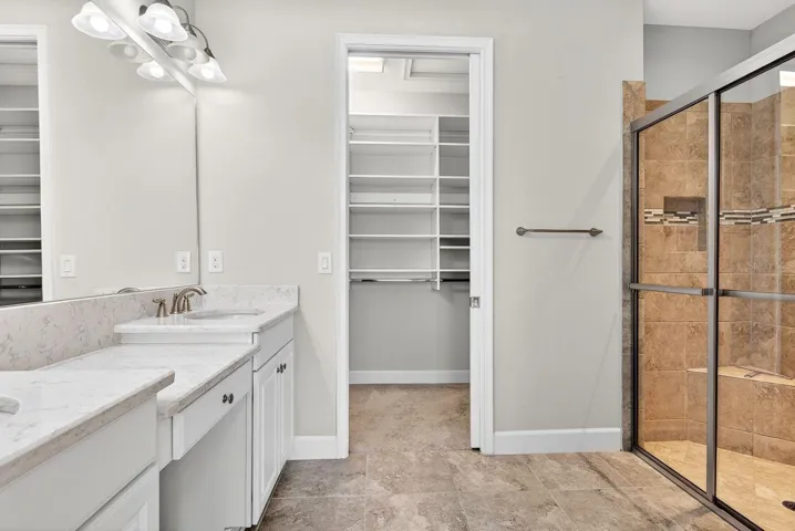 Primary En-suite with double vanities, make-up area, walk-in closet iwth built ins, shower with built in bench and upgraded tile, private water closet
