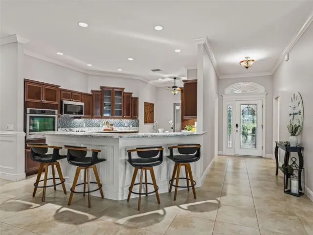 Kitchen area and entrance foyer. Notice the wooden millwork and transom at Front Door - Stunning