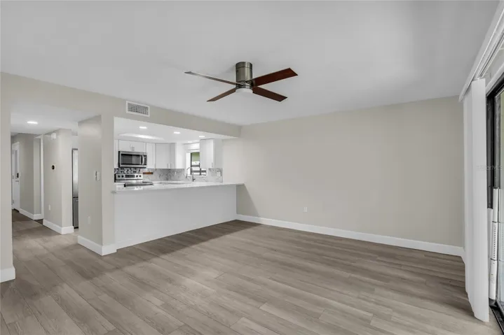 Living room includes a cozy dining area and opens to a covered patio and spacious yard that’s fully fenced in