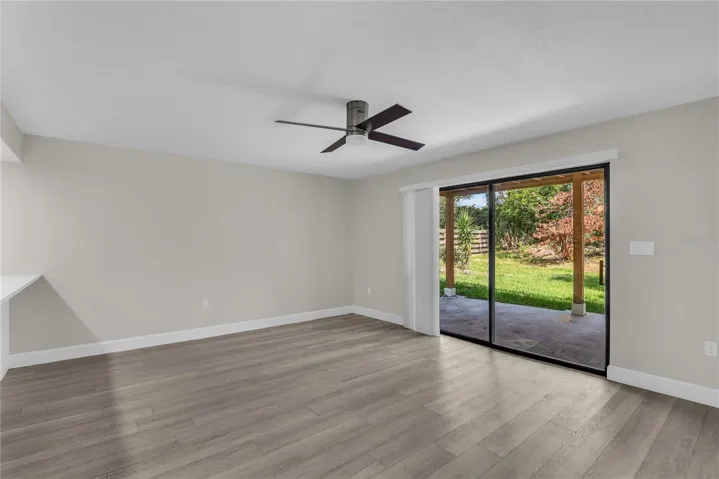 Living room includes a cozy dining area and opens to a covered patio and spacious yard that’s fully fenced in