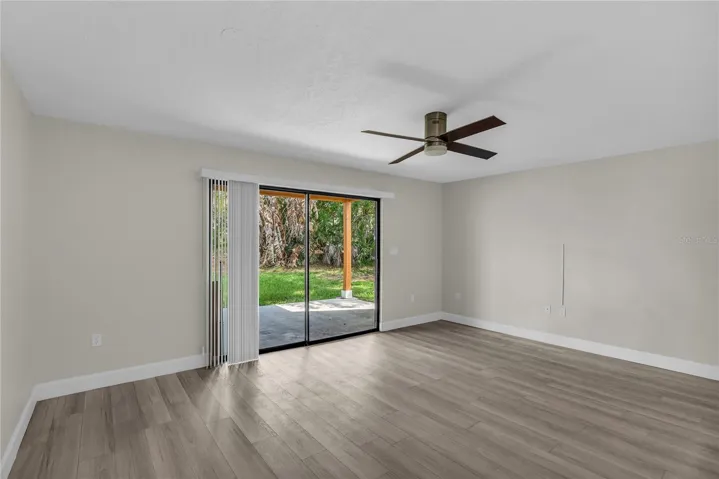 Living room includes a cozy dining area and opens to a covered patio and spacious yard that’s fully fenced in