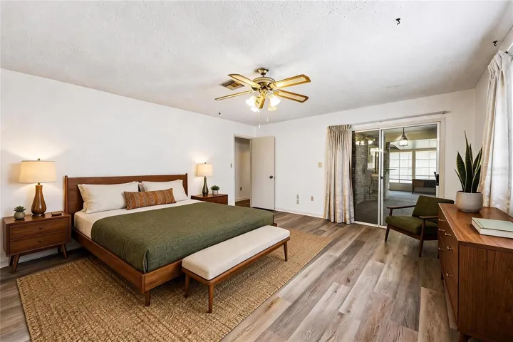 Spacious primary suite has its own access to the enclosed lanai. Virtually Staged.