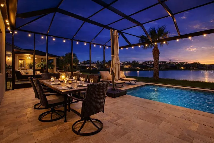 Evening View of the Backyard Featuring a Heated Pool with Bubblers and Fountain Features