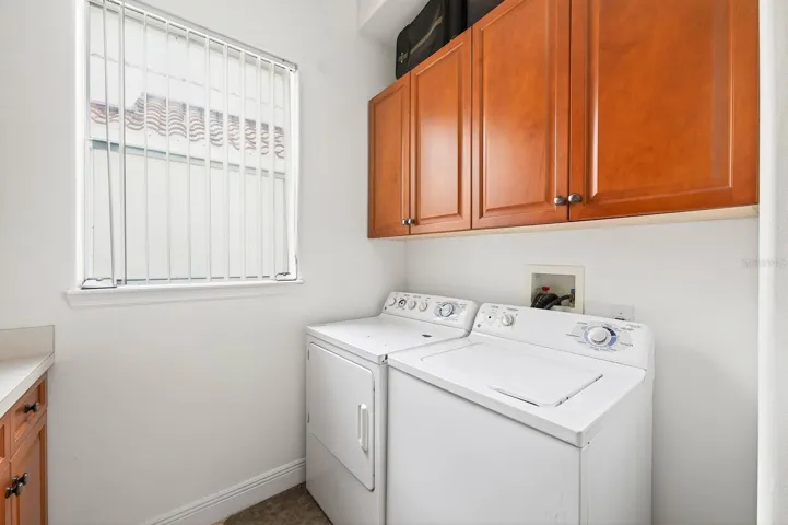 A spacious laundry room with abundant storage cabinetry adds convenience and functionality to the first floor.