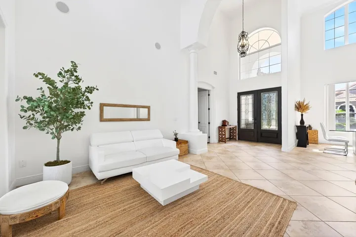 The BREATHTAKING ENTRANCE, highlighted by a dramatic 30-foot ceiling, sets the tone for the elegance found throughout the home.