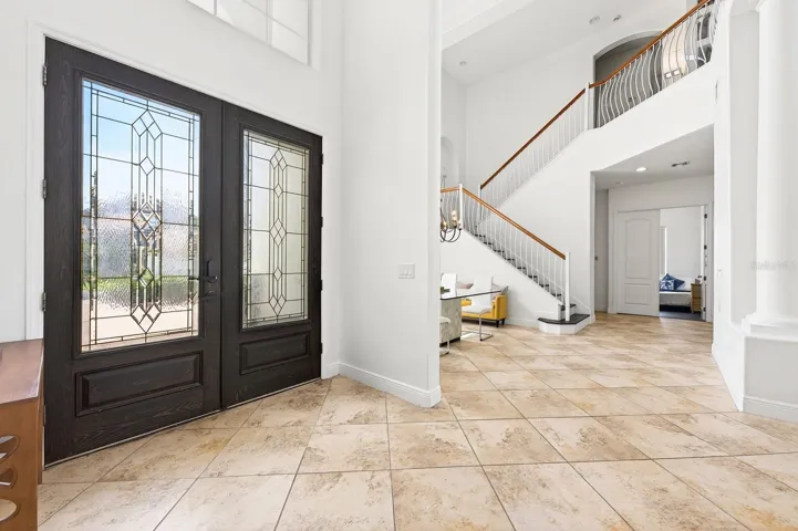 The BREATHTAKING ENTRANCE, highlighted by a dramatic 30-foot ceiling, sets the tone for the elegance found throughout the home.