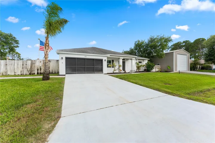 Paver driveway leading to a spacious garage and welcoming entryway
