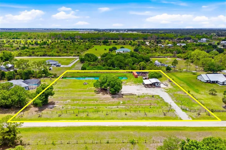 Ariel view of property with fruit trees in the front and livestock area in the back right corner.