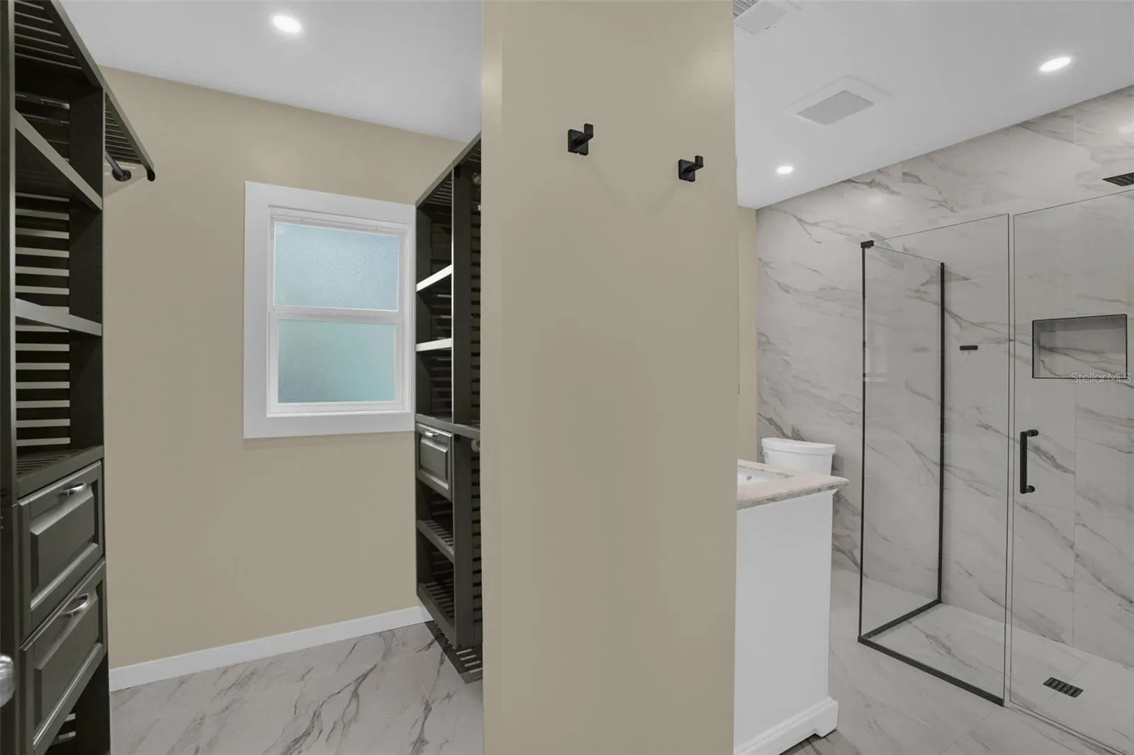 Fully remodeled primary bathroom featuring a custom glass shower enclosure, designer tile, and modern vanity.