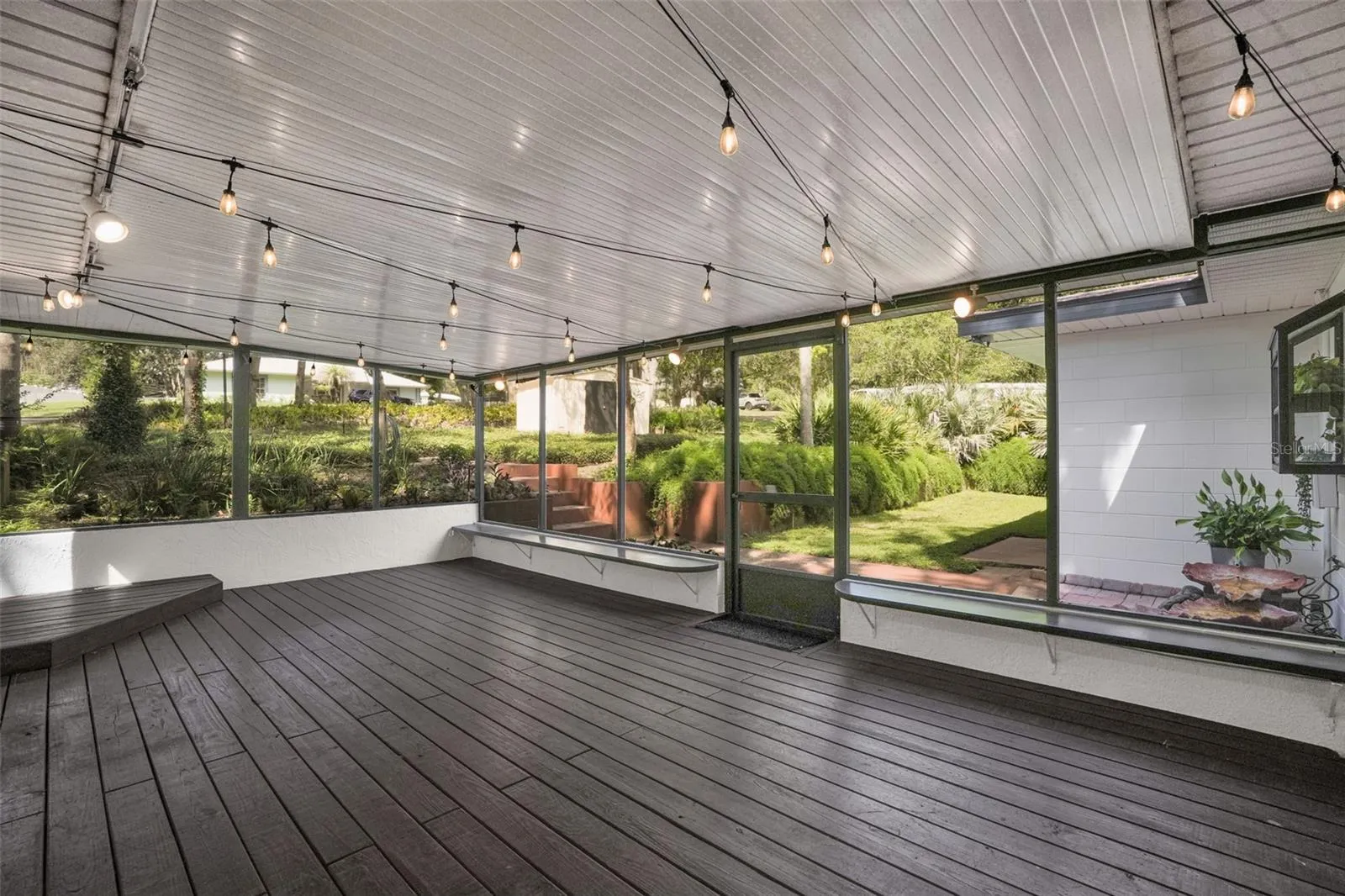 Another view of the oversized screened patio overlooking the peaceful backyard and mature landscaping